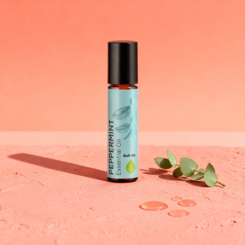 Pure Peppermint Oil Rollerball on a blush pink surface with eucalyptus